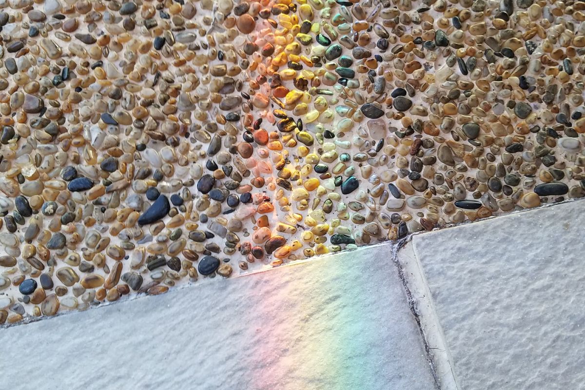 Exposed aggregate concrete surface with pebbles beside smooth paving